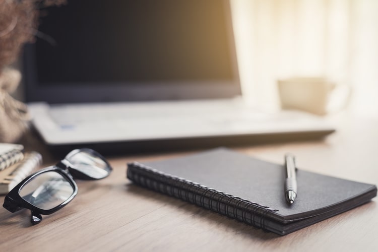 photo of a laptop with a notepad